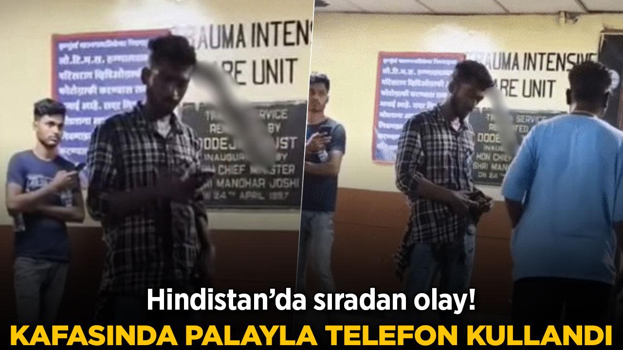 Başında palayla telefon kullanmaya devam etti